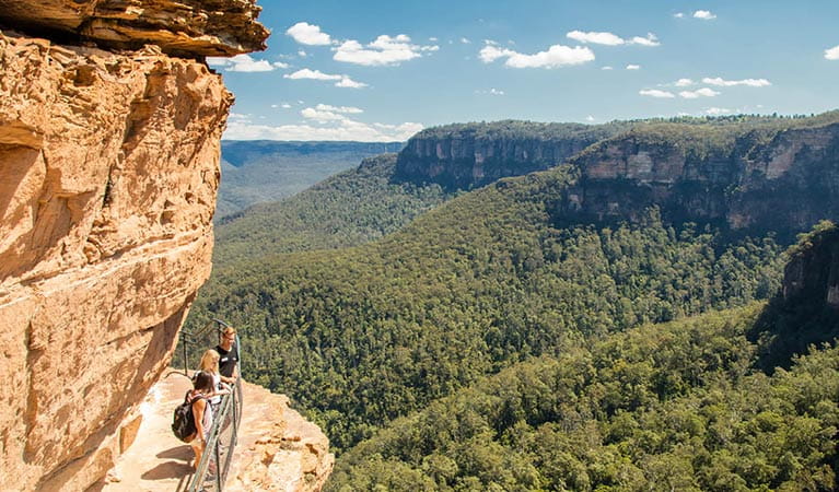 Three visitors enjoy views from National Pass at Wentworth Falls, Blue Mountains National Park. Photo: OEH