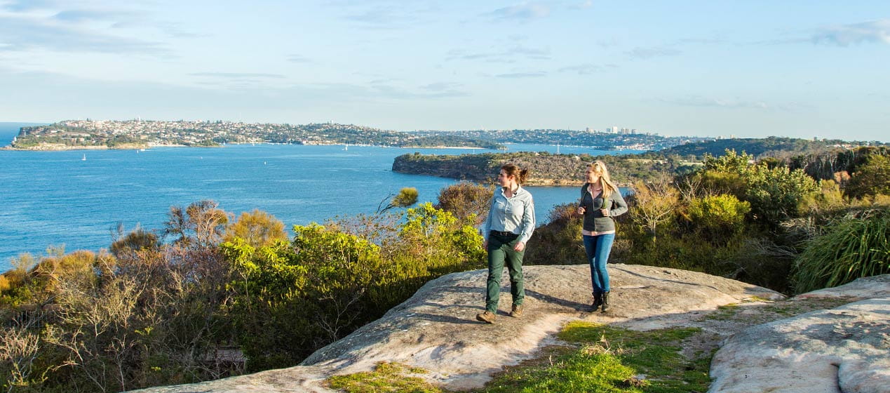 Two women walk along Manly Scenic Walk, near Dobroyd Head, Sydney Harbour National Park. Photo: Simone Cottrell &copy; DPIE